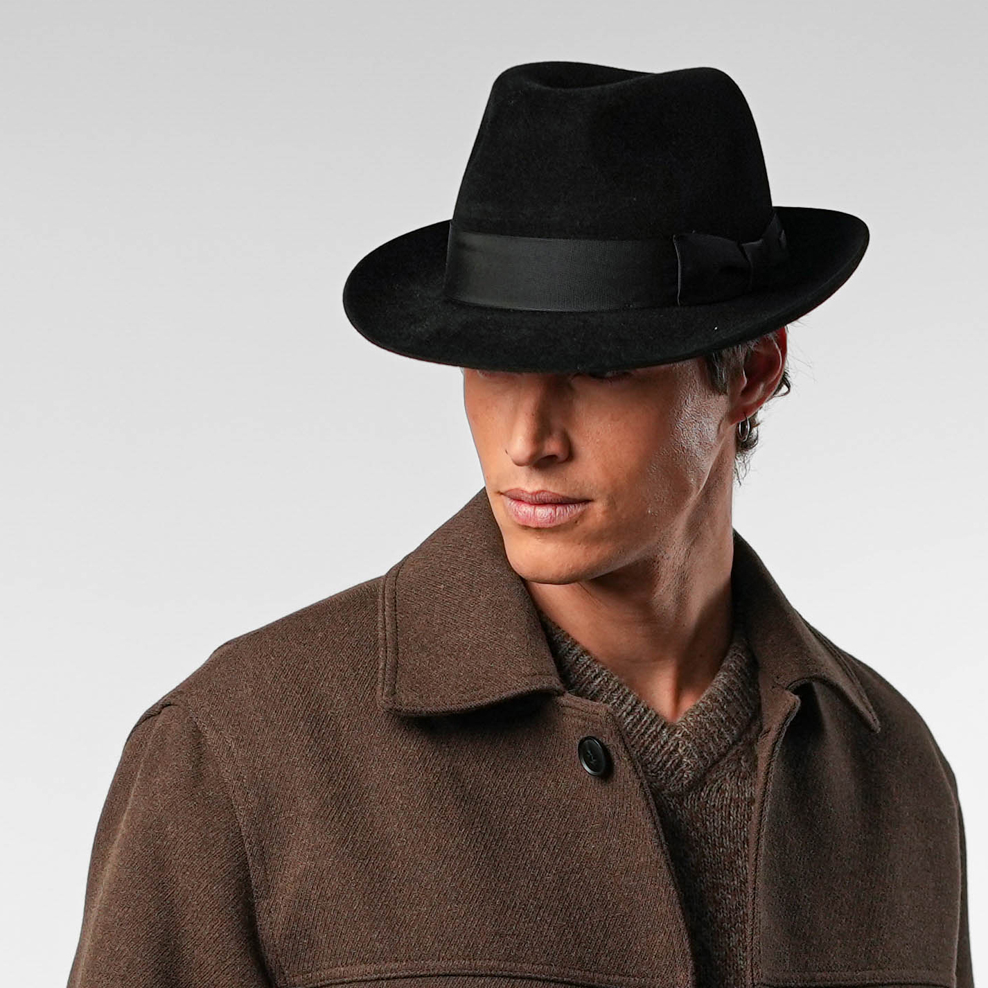 Fedora inclinato in avanti, mistero e intensità